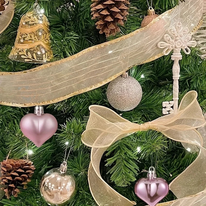 Boules de Noël roses incassables aux finitions mates et givrées suspendues sur un sapin décoré