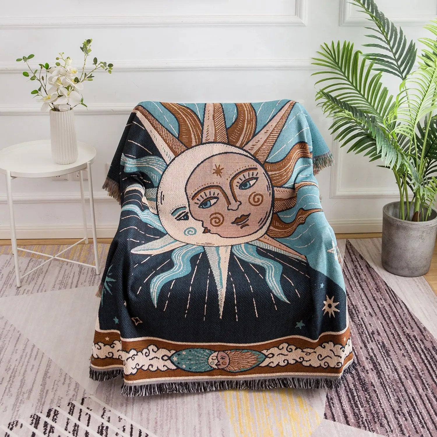 Tapisserie plaid soleil et lune drapée sur un fauteuil avec plantes