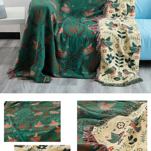 Plaid bohème vert forêt motifs oiseaux drapé sur un fauteuil