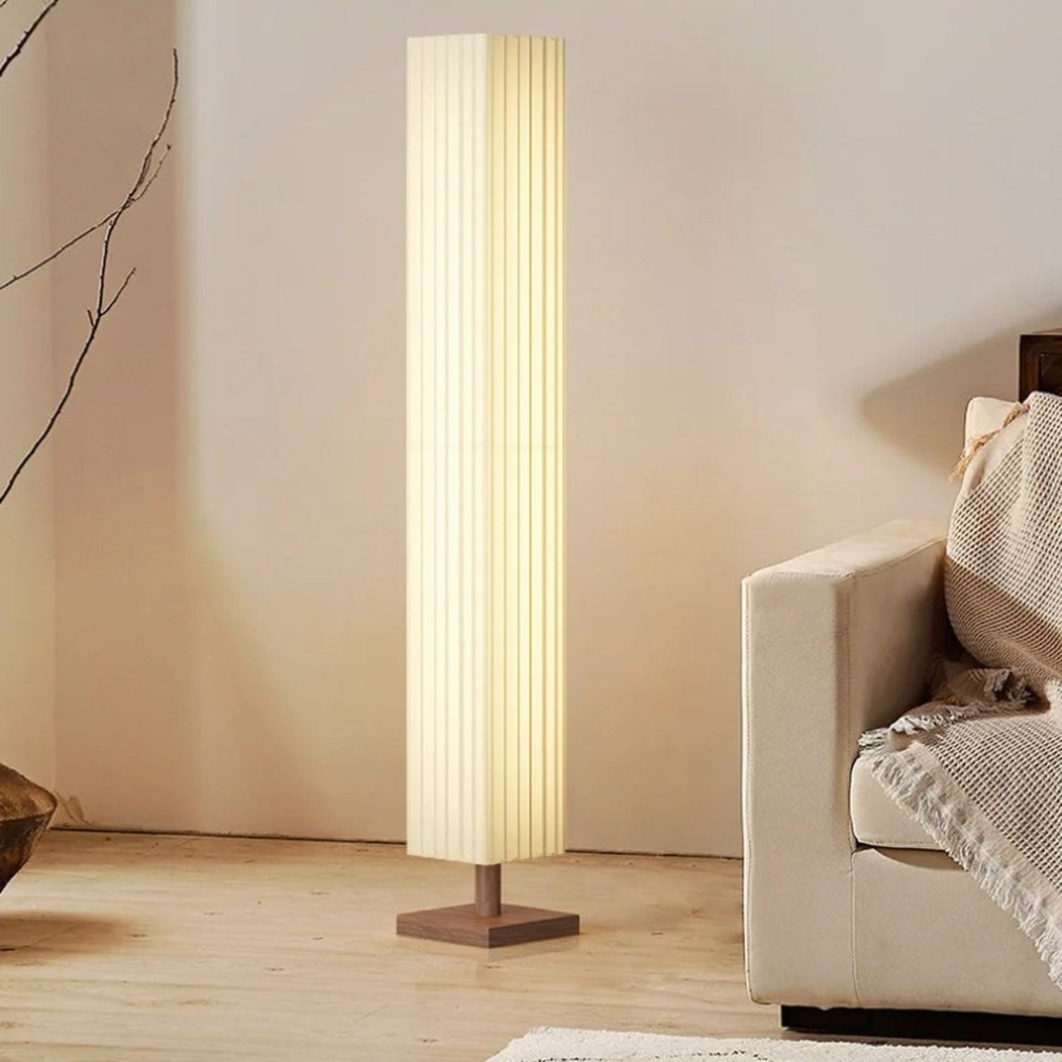 Lampadaire sur pied en tissu plissé à côté d'un canapé en lin