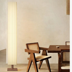 Lampadaire en tissu plissé dans une salle à manger avec chaise en rotin