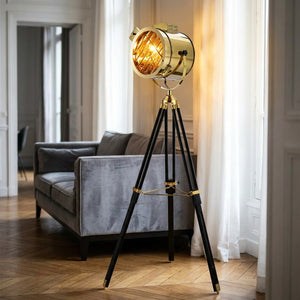 Lampadaire projecteur trépied doré dans salon parisien élégant