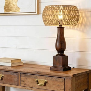 Abat-jour en corde de papier allumé sur une lampe en bois posée sur une console
