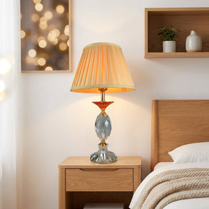 Abat-jour plissé en tissu beige sur lampe de table dans une chambre chaleureuse