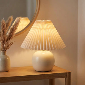 Abat-jour plissé beige sur une lampe d'entrée près d'un miroir rond
