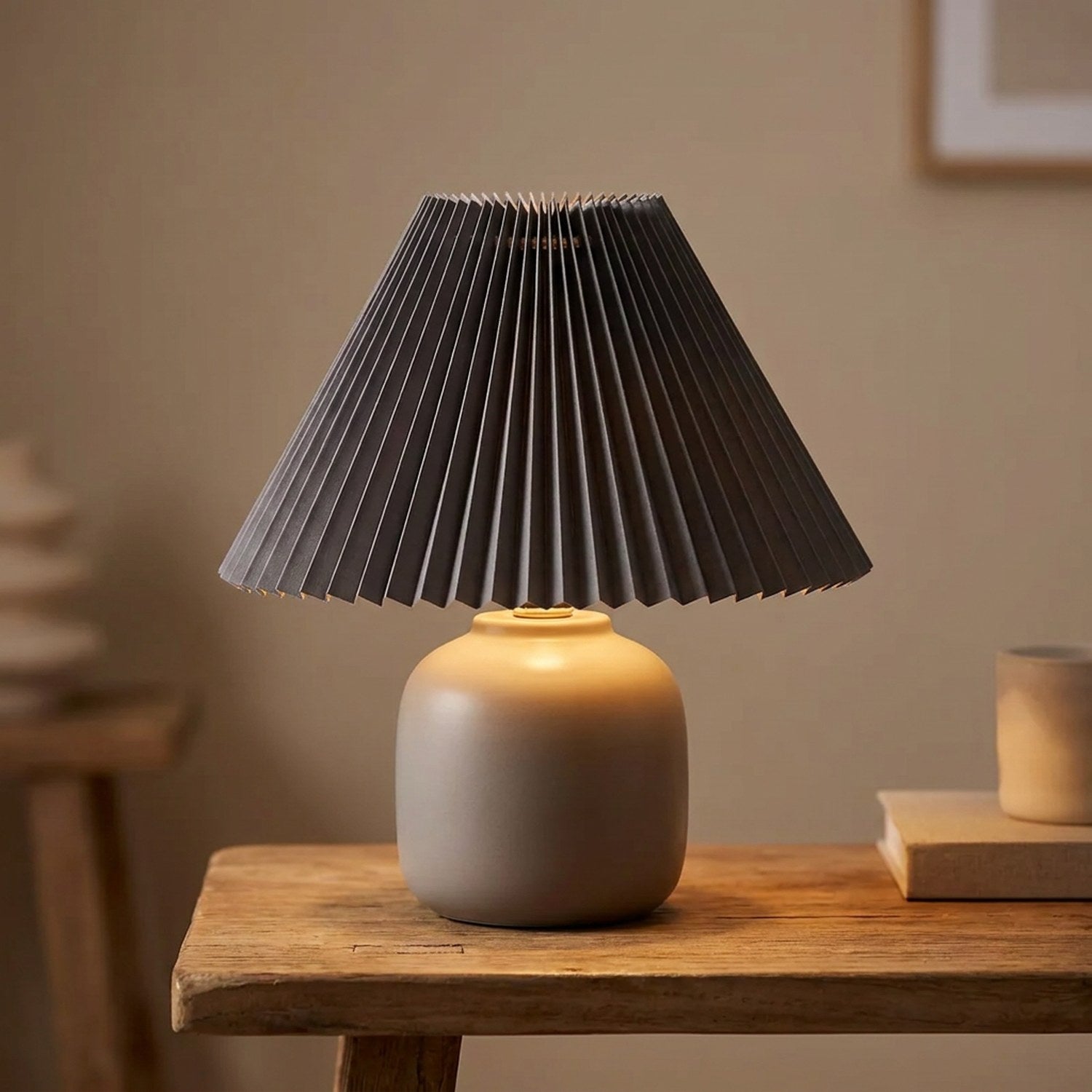 Abat-jour plissé conique en tissu coloris Gris sur une lampe allumée