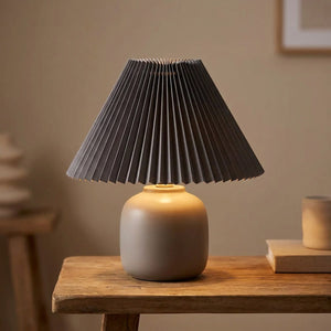 Abat-jour plissé conique en tissu coloris Gris sur une lampe allumée
