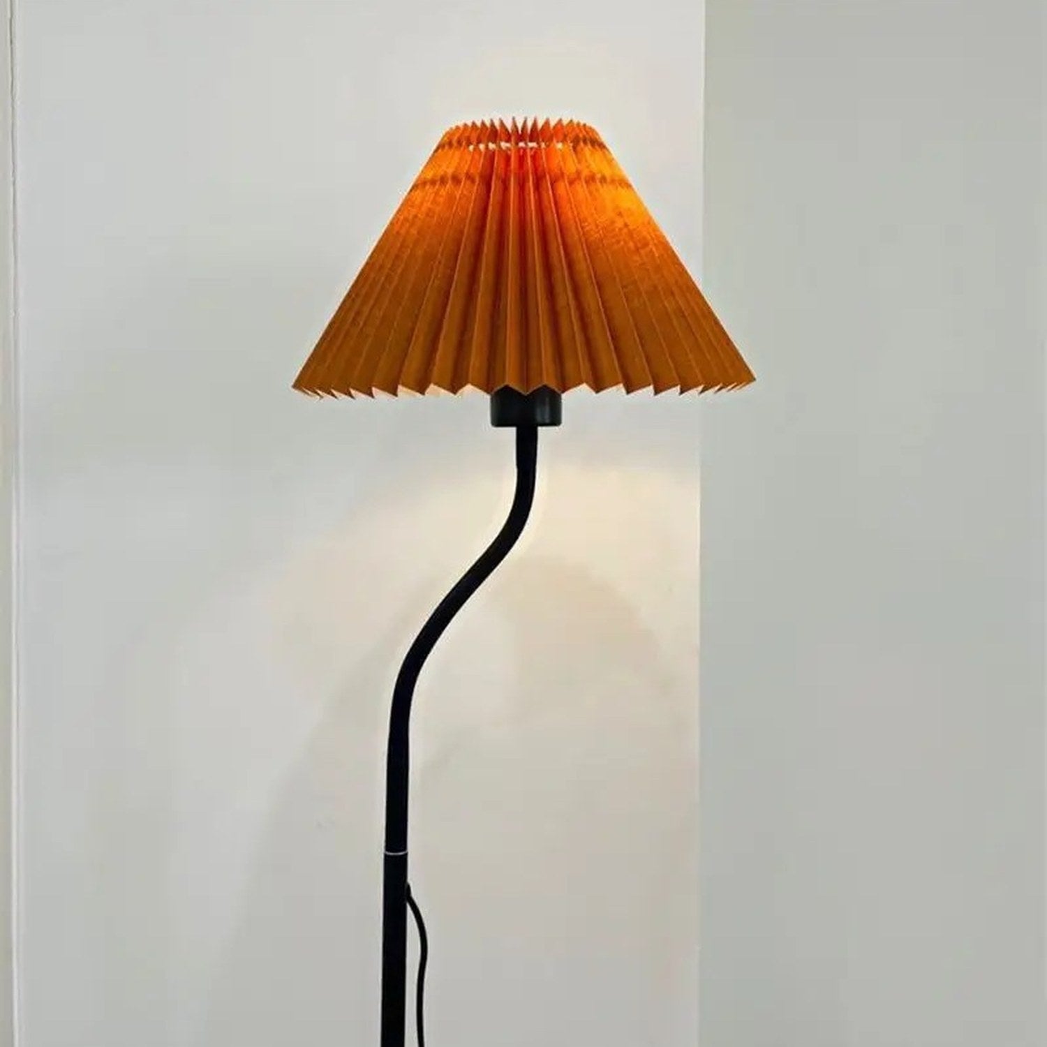 Abat-jour plissé orange de style japonais installé sur un lampadaire allumé