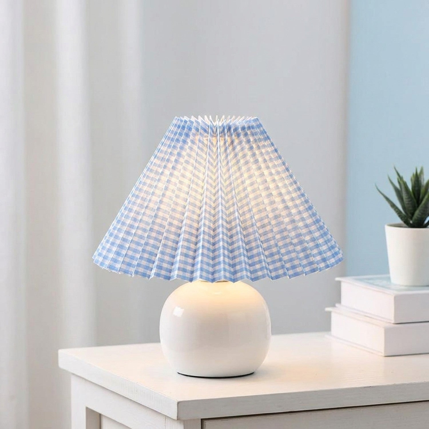 Abat-jour plissé bleu clair vichy tissu style japonais sur lampe céramique allumée