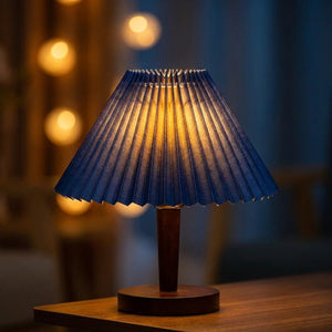 Abat-jour plissé bleu foncé tissu style japonais sur lampe bois allumée ambiance soirée