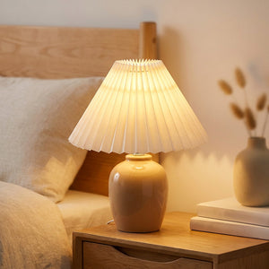 Abat-jour plissé en tissu blanc de style japonais sur lampe de table allumée dans une chambre chaleureuse