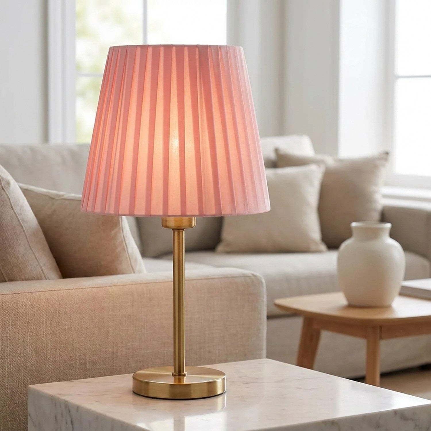 Abat-jour plissé rose sur lampe dorée dans un salon moderne