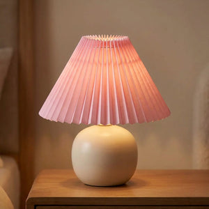 Abat-jour plissé conique en tissu coloris Rose sur une lampe allumée