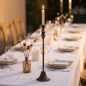 Chandelier en fer laiton antique sur une table de mariage dressée en blanc