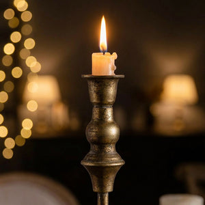 Gros plan sur le sommet du chandelier en fer laiton antique avec bougie allumée