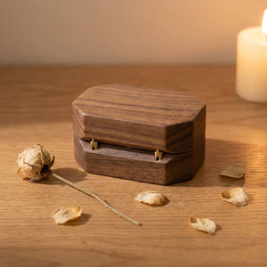 Écrin à bague en bois de noyer fermé avec fleurs séchées et bougie romantique