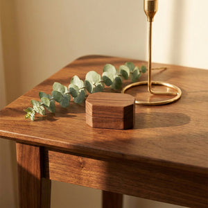Boîte à bijoux vintage en bois fermée sur table avec branche d'eucalyptus et bougeoir doré