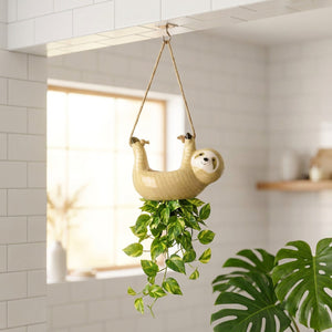 Pot suspendu céramique paresseux jaune dans salle de bain minimaliste avec pothos