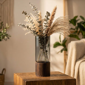 Vase cylindrique en verre fumé avec base en bois wengé et branches de pampa séchées