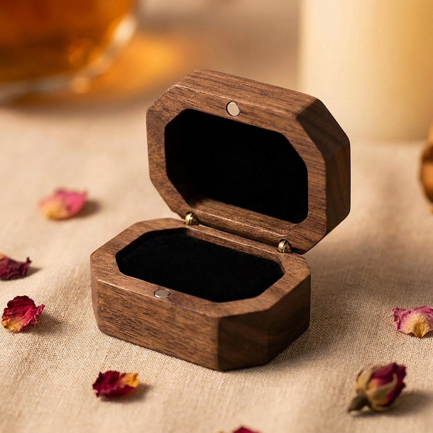 Boîte à bijoux vintage en bois de noyer ouverte sur fond de pétales de rose