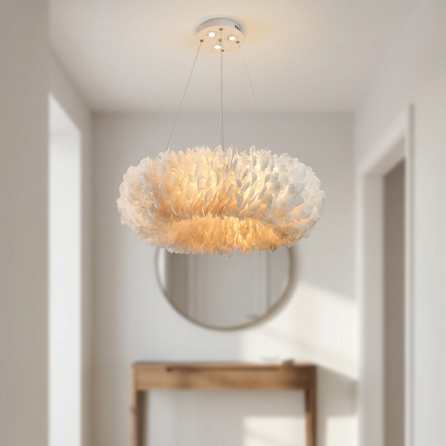 Lustre suspension en plumes blanches dans une entrée lumineuse avec miroir rond
