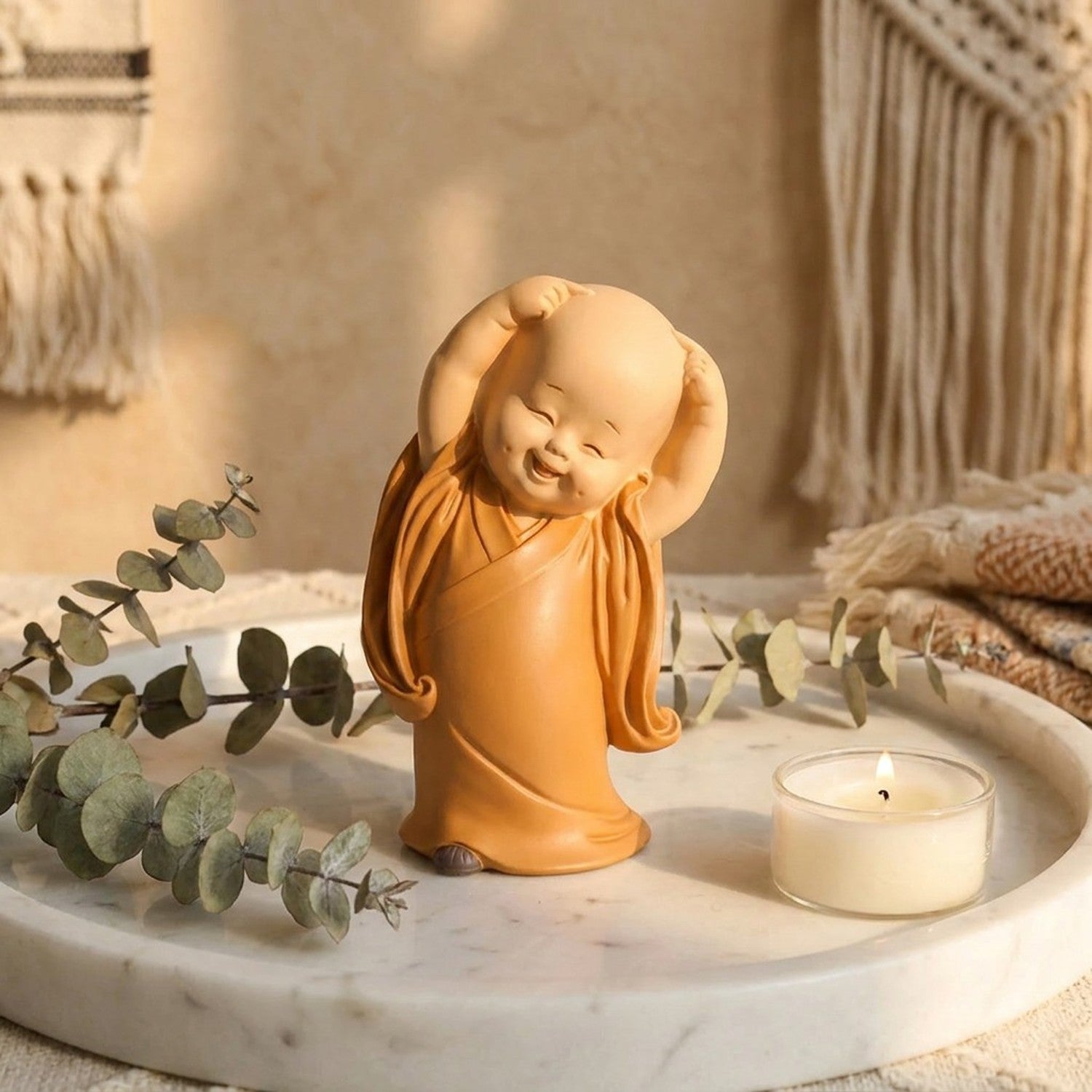 Mini statuette moine résine bras levés sur plateau marbre avec eucalyptus et bougie blanche décoration boho zen