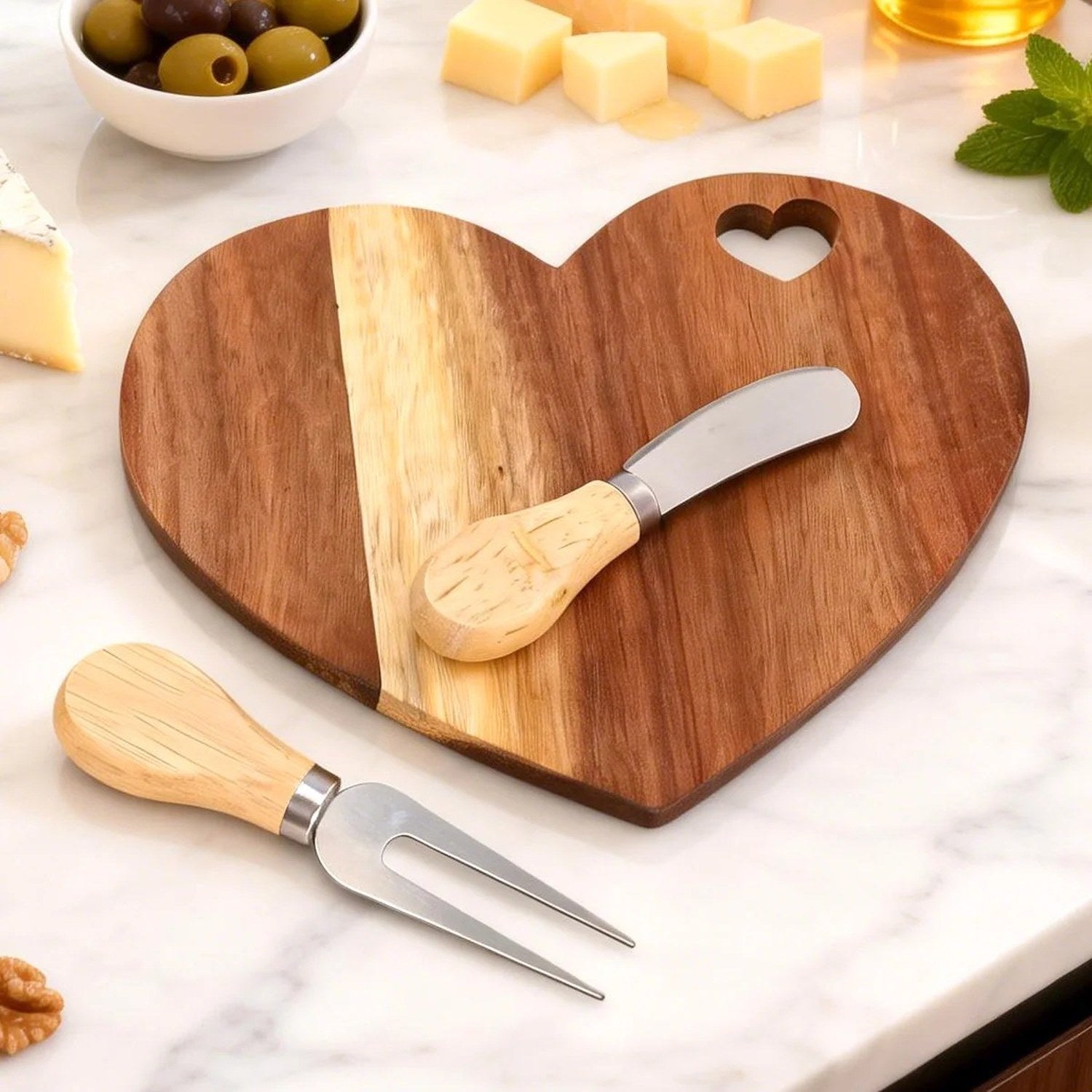 Ensemble planche apéritif cœur en bois avec olives fromages et noix sur marbre