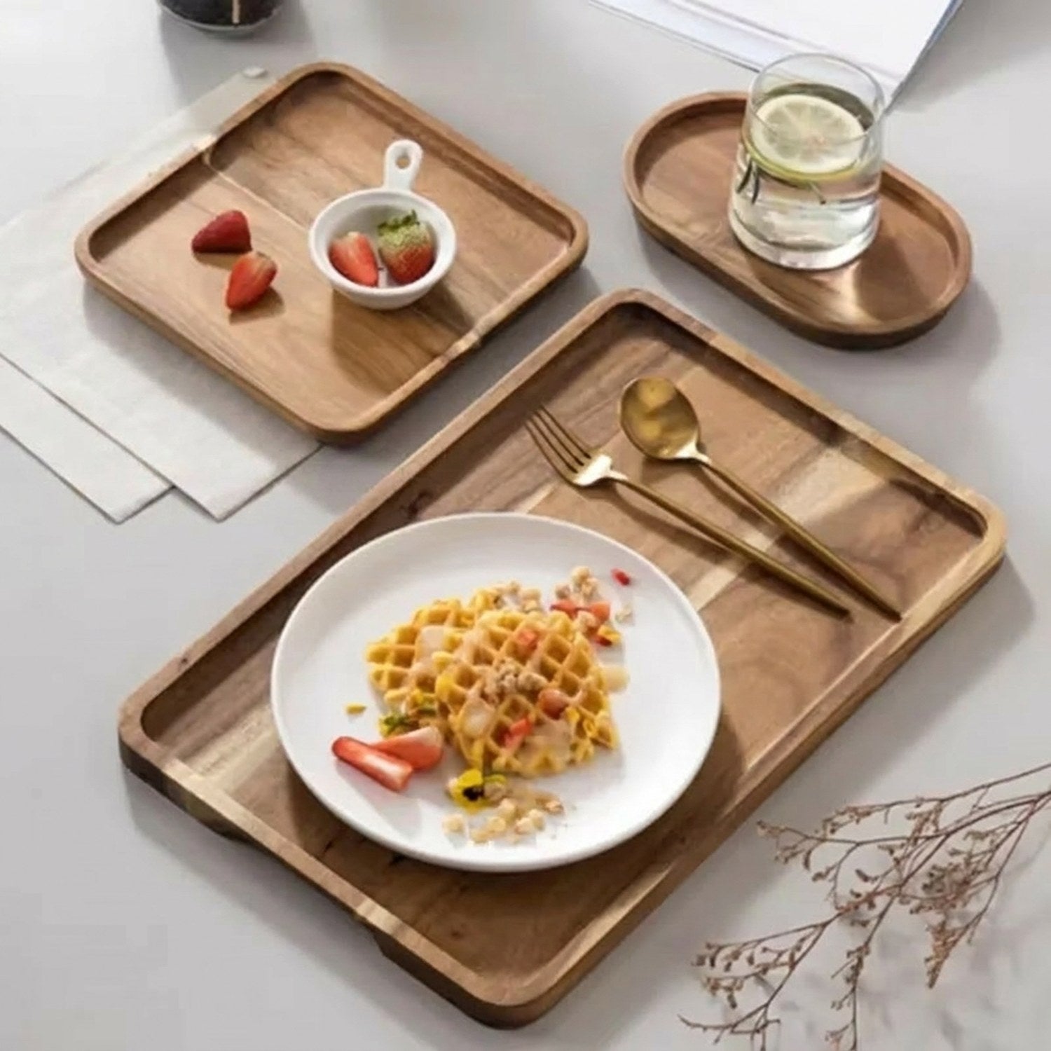Vue d'ensemble de plateaux en bois d'acacia naturel avec aliments et vaisselle