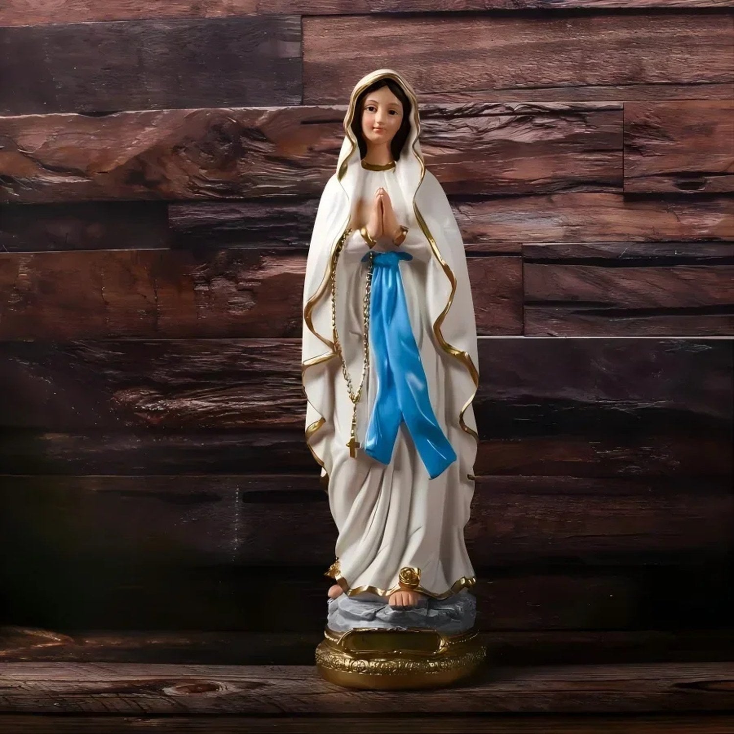 Photo AliExpress statue Vierge Marie en résine peinte robe blanche écharpe bleue socle doré vue de face sur fond bois