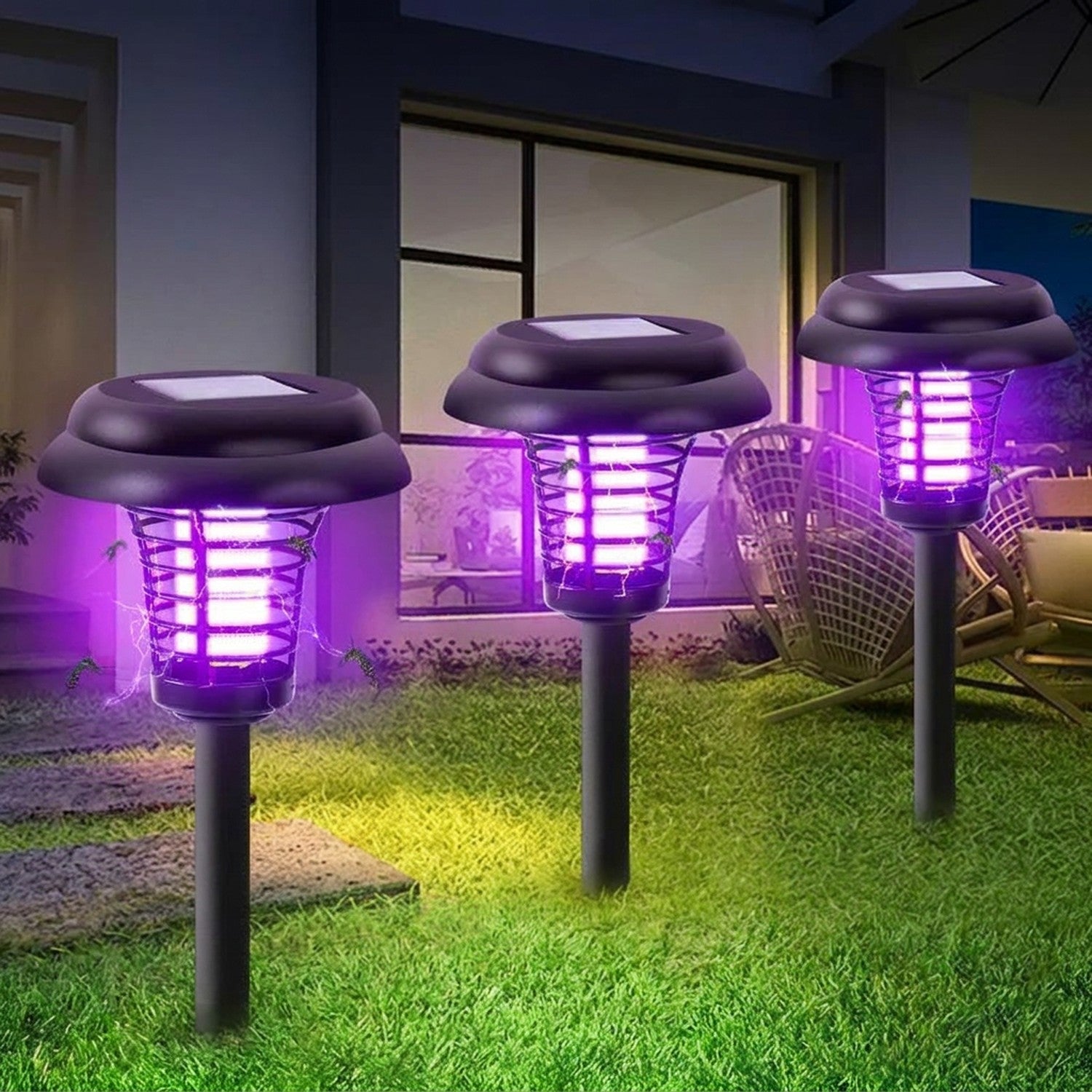 Trois lampes anti-moustiques solaires allumées dans un jardin la nuit