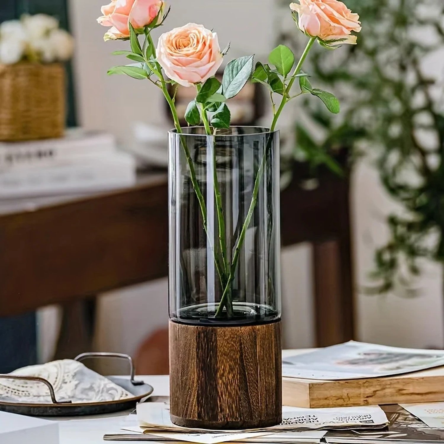 Vase en verre fumé avec base en bois wengé et roses roses sur fond bokeh