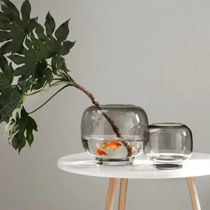 Vase bulle gris avec branche d'arbre et poissons rouges