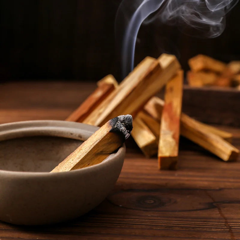 Bâton d'encens Palo Santo en combustion dans bol céramique avec fumée
