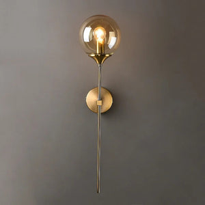 Applique murale boule de verre ambrée allumée avec ampoule filament sur mur dégradé