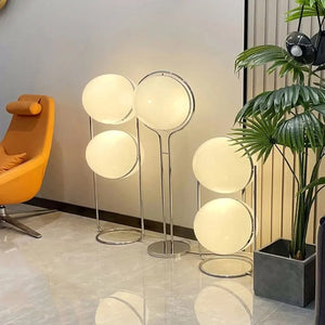 Lampadaires boule chromés dans un salon avec fauteuil orange et plante