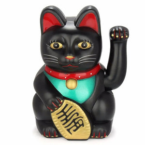 Figurine chat porte-bonheur noir avec collier rouge et bavoir vert sur fond blanc