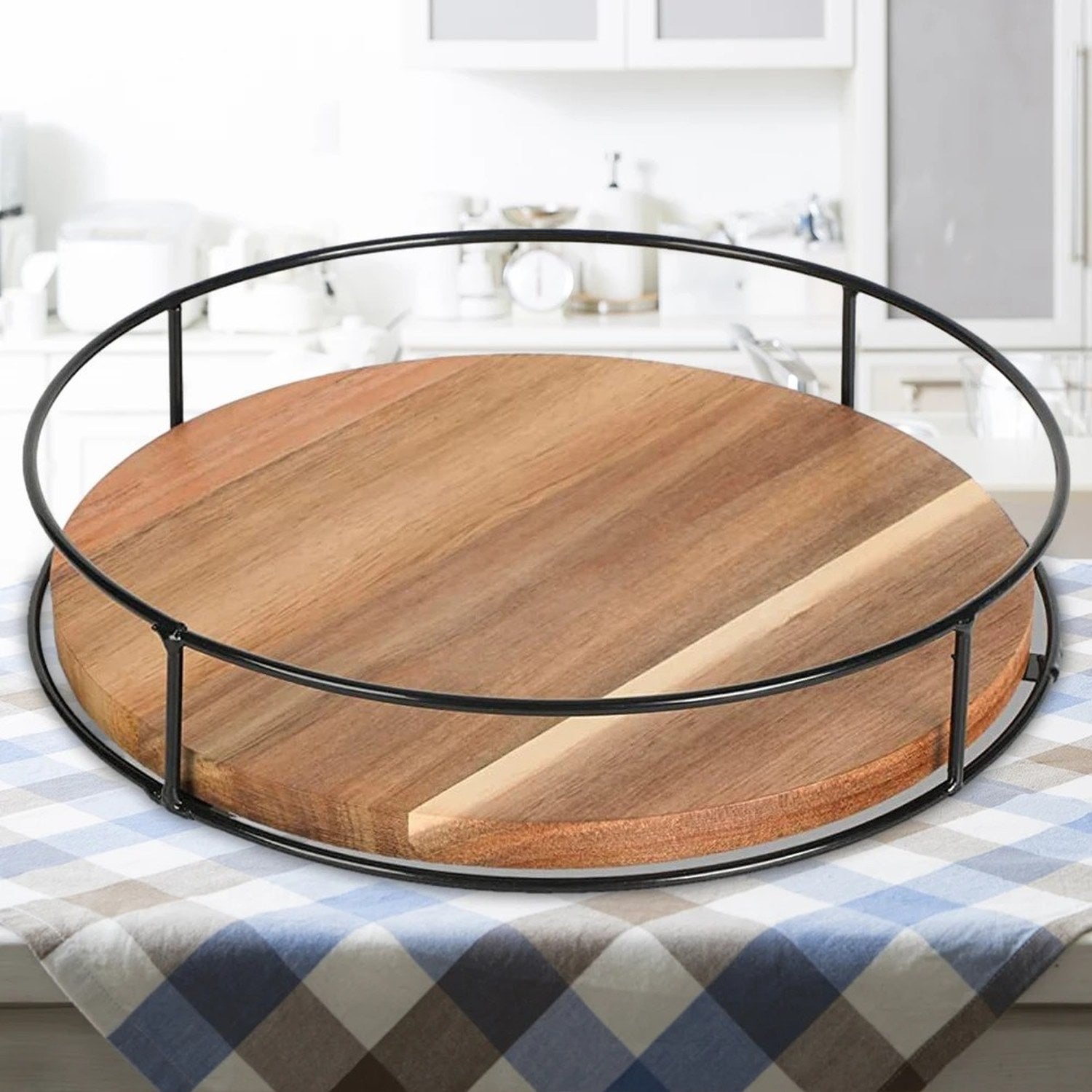 Vue du plateau tournant en bois et métal noir posé sur une nappe à carreaux, cuisine en arrière-plan