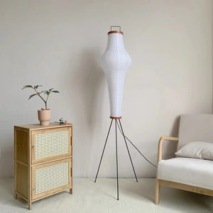 Lampadaire trépied papier de riz dans un intérieur naturel avec meuble rotin