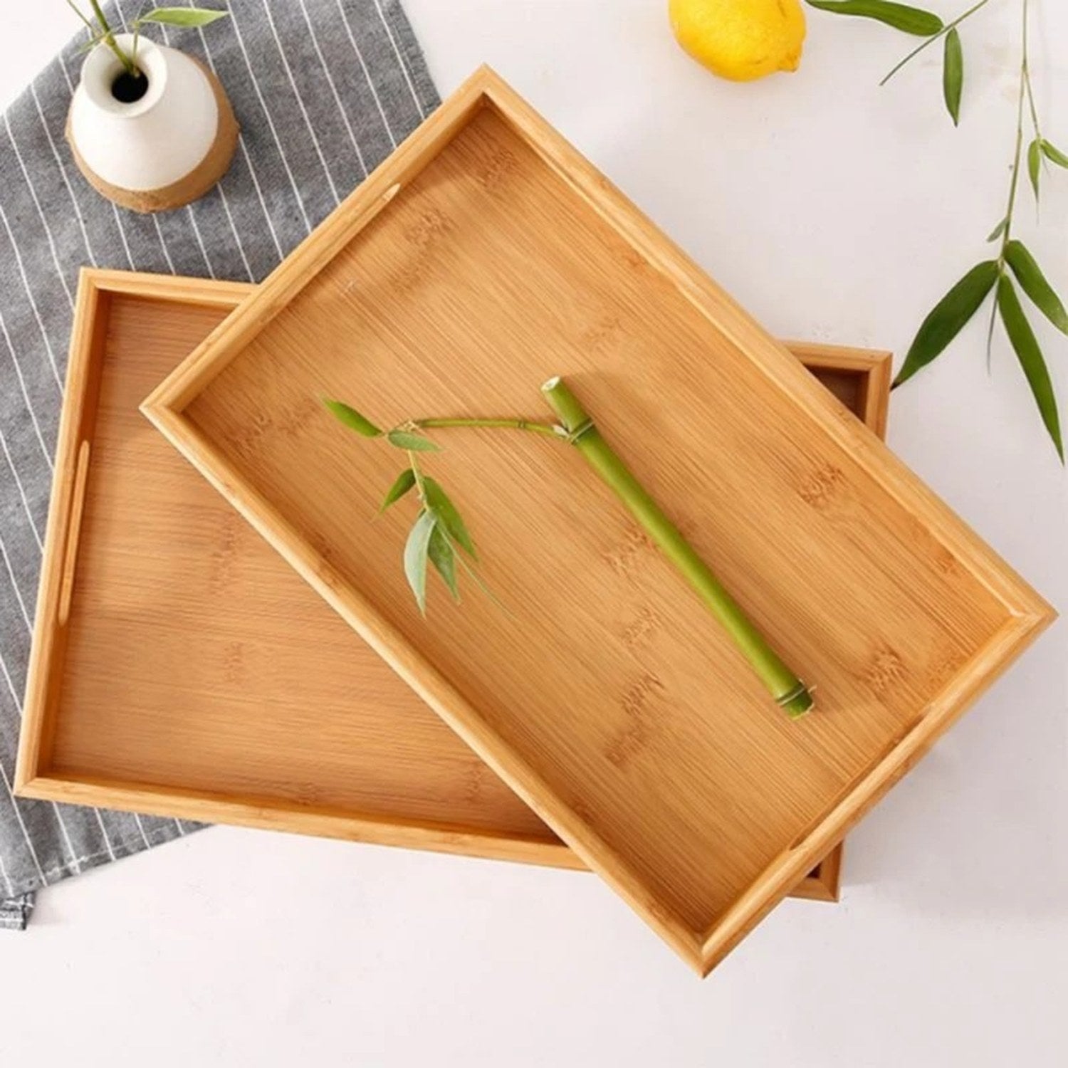 Plateau en bambou avec tige bambou vase blanc et citron sur surface claire
