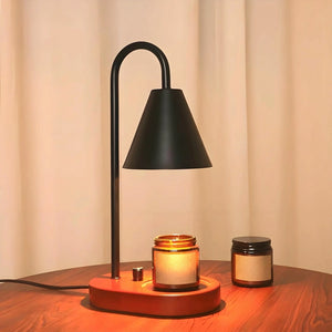Chauffe-bougie électrique noir allumé sur table en bois avec pots de cire