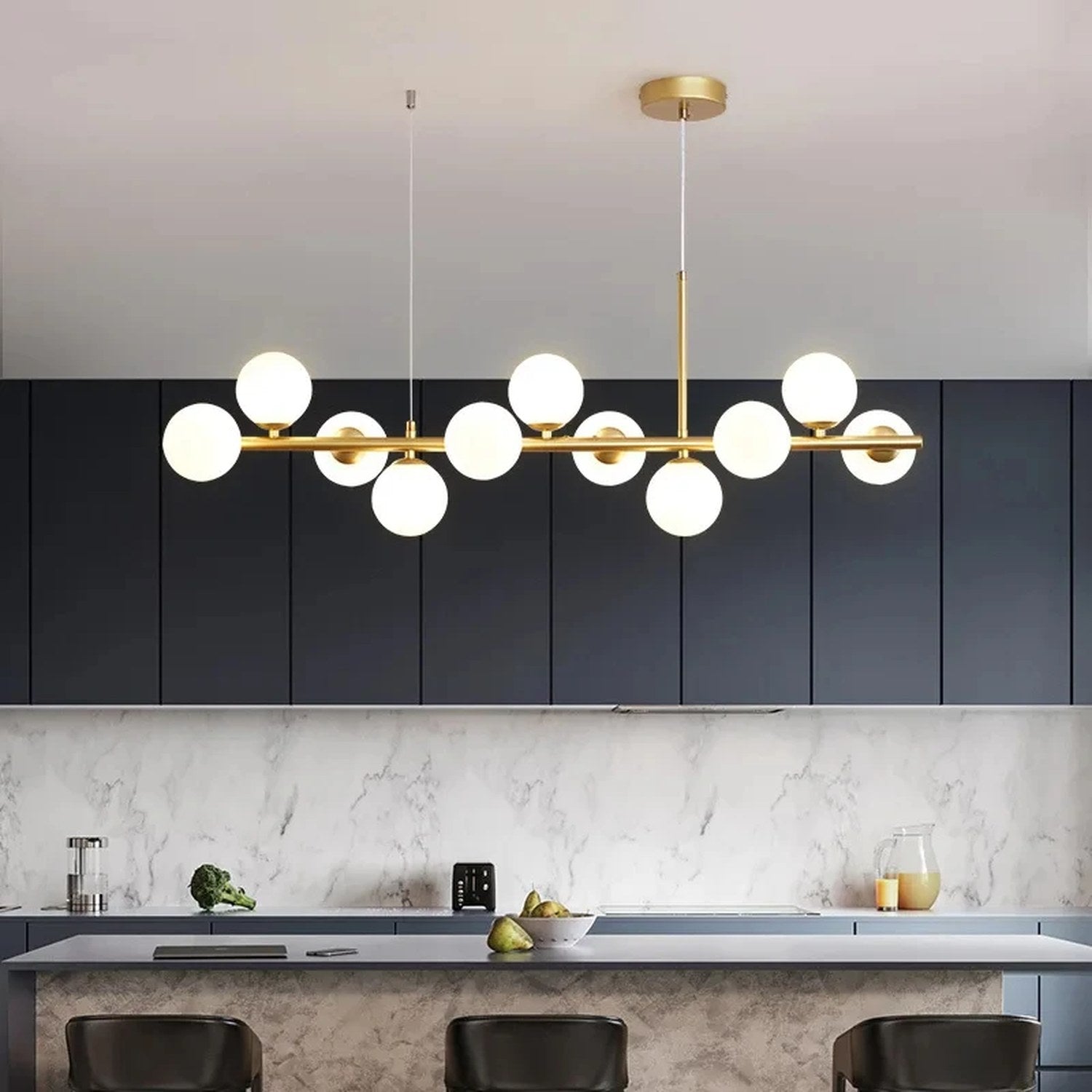 Lustre doré à globes de verre opalin suspendu au dessus d'un îlot de cuisine