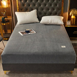 Drap-housse gris anthracite installé sur un lit fait dans une chambre chic