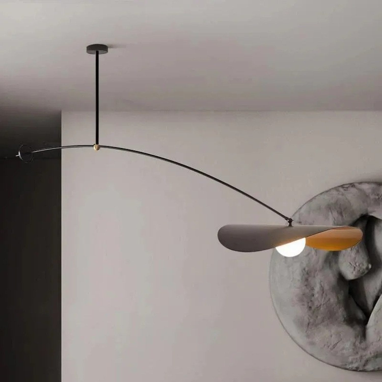 Suspension nordique noire et dorée déployée au-dessus d'une console avec sculpture murale
