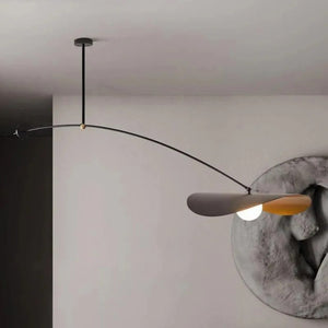 Suspension nordique noire et dorée déployée au-dessus d'une console avec sculpture murale