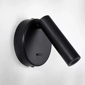 Applique murale ronde noire vue de face sur fond clair avec spot orientable et interrupteur intégré