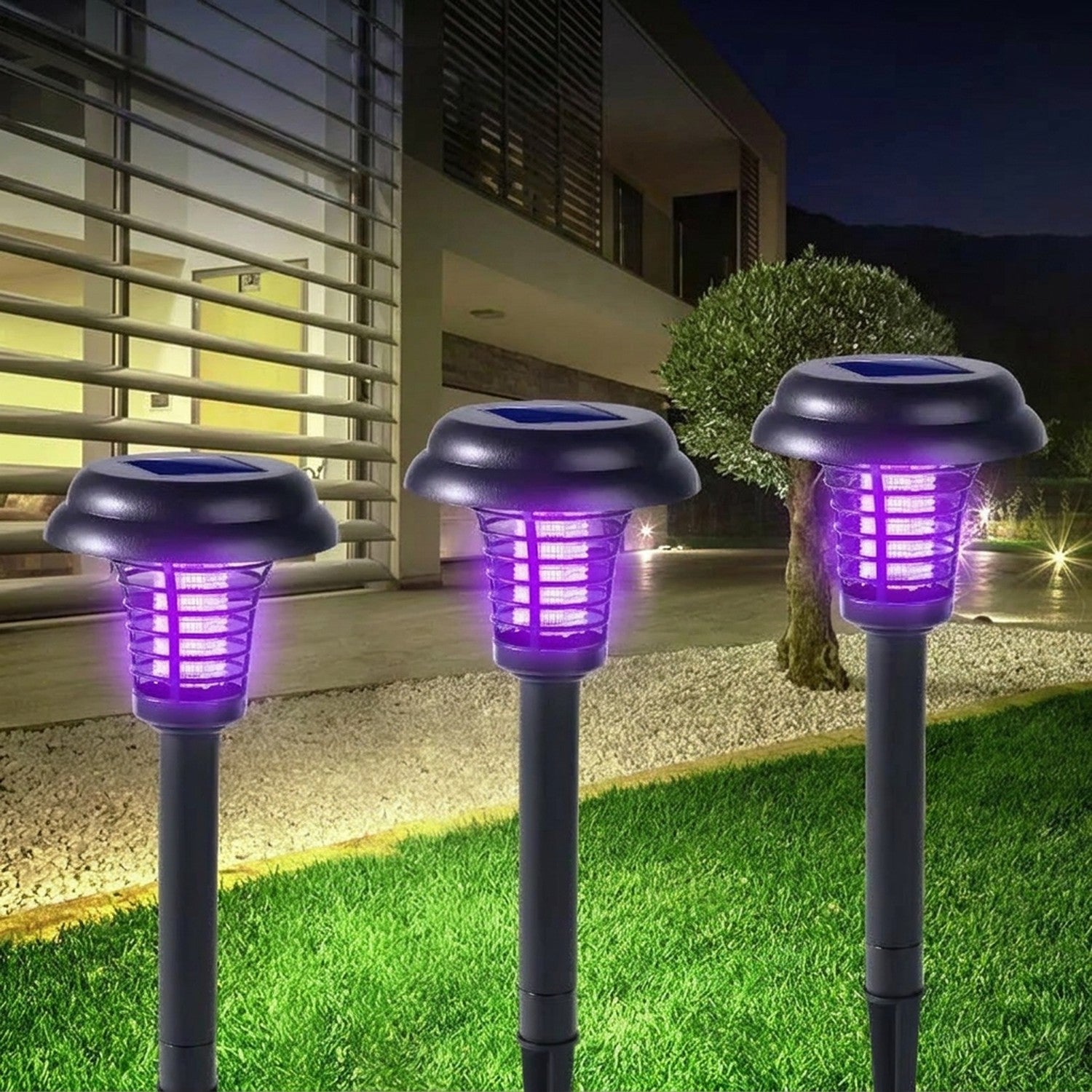 Lampes anti-moustiques solaires dans un jardin avec maison moderne en arrière-plan