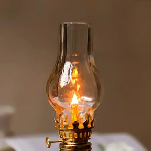 Gros plan sur la flamme dorée à travers le globe en verre de la lampe