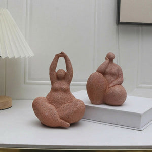 Statuette femme yoga et statuette femme pensive en résine sableuse sur console blanche
