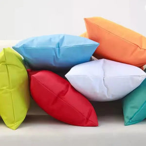 Housses de coussin extérieur multicolores empilées sur un canapé