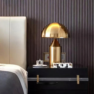 Lampe de table champignon dorée sur une table de chevet noire dans une chambre de luxe